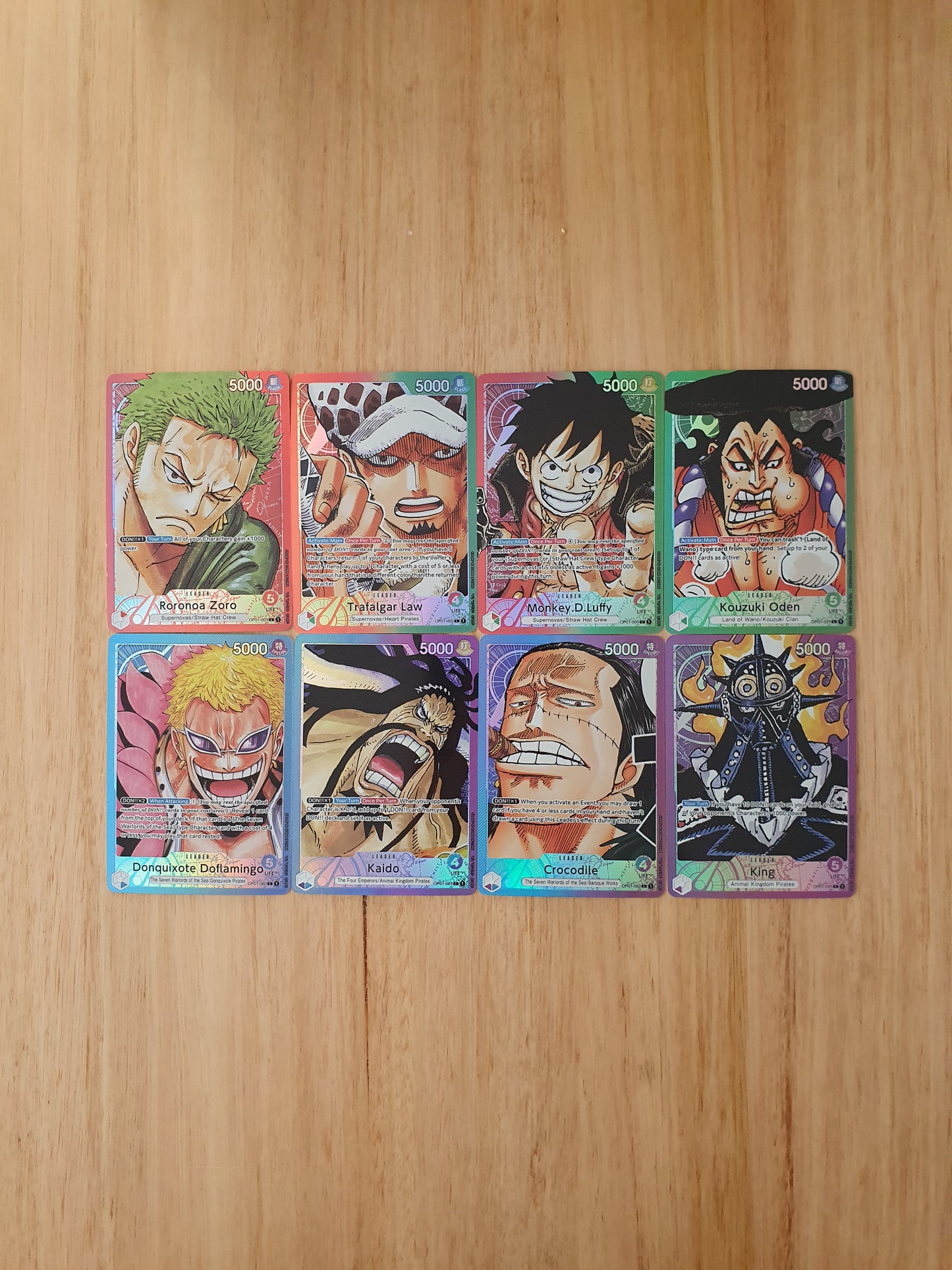A collection of 8 custom-made proxy trading cards featuring characters from the anime One Piece, laid out on a wooden surface.